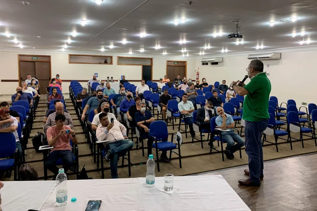 Palestrante de camisa verde fala para a plateia no auditório do congresso de Campinas